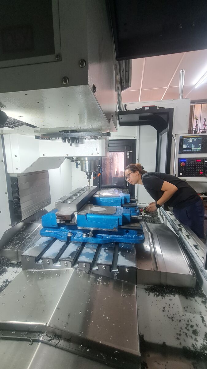 CNC machining centre in operation with machinist